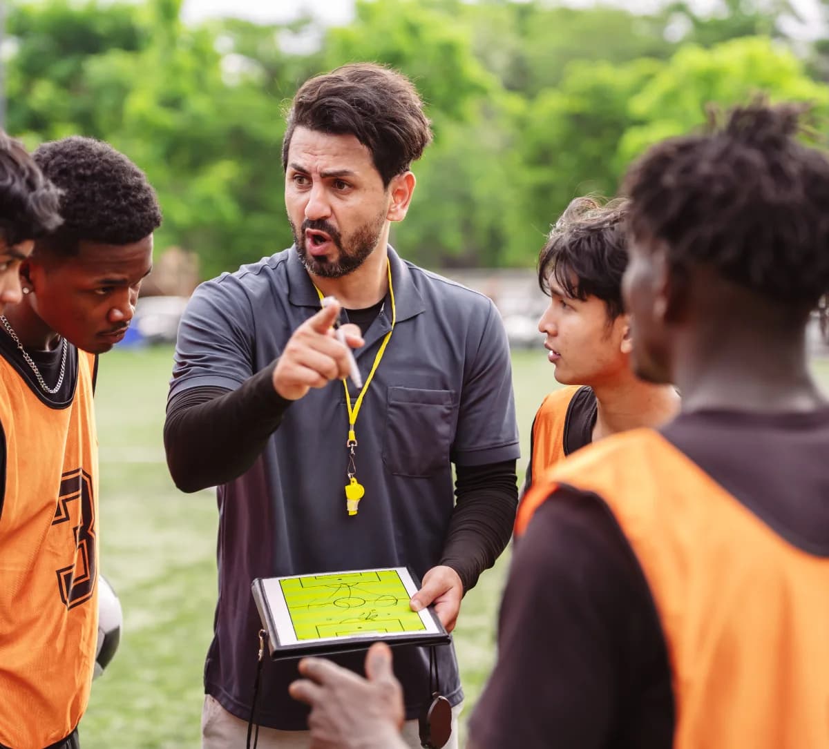 Entrenador explicando una táctica a un grupo de futbolistas